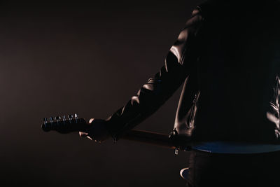 Rear view of man standing against black background