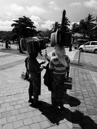 Rear view of people walking on road