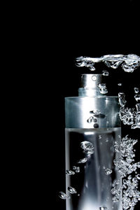 Close-up of water glass against black background