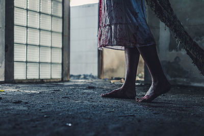 Low section of woman standing on floor in city