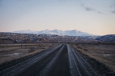 Road leading towards mountains against sky