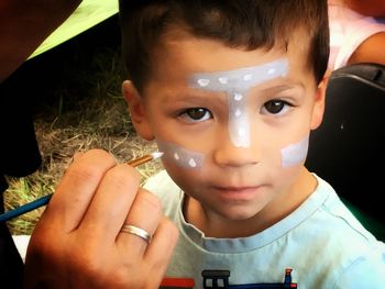 Close-up portrait of boy holding camera