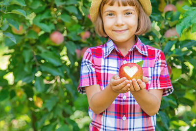 Cute girl wearing hat holding apple fruit