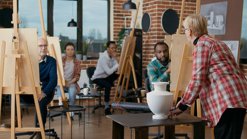 Teacher showing vase to student in art class