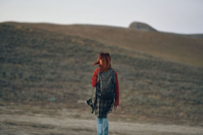 Rear view of woman standing on landscape