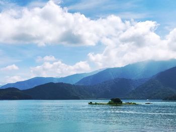 Scenic view of sea and mountains against sky