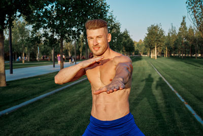Portrait of young man exercising in park