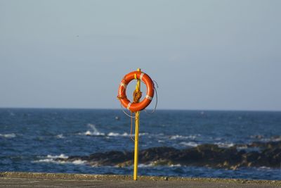 Information sign on beach against clear sky