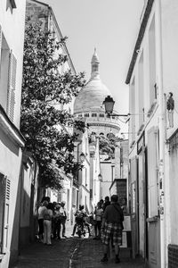 People walking in temple against sky in city