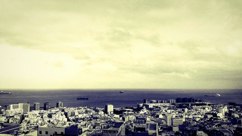 High angle view of townscape by sea against sky