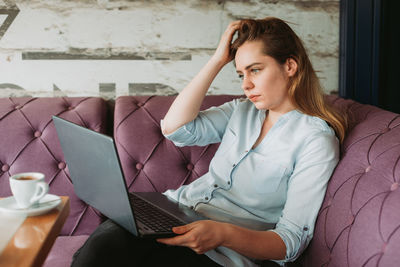 Young woman using mobile phone at home