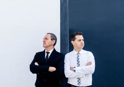Portrait of friends standing by wall