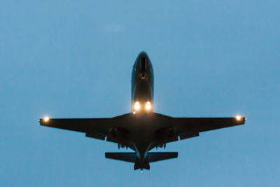 Low angle view of airplane against clear blue sky