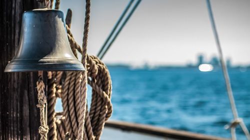 Bell and hanging ropes on cruising yacht near the city