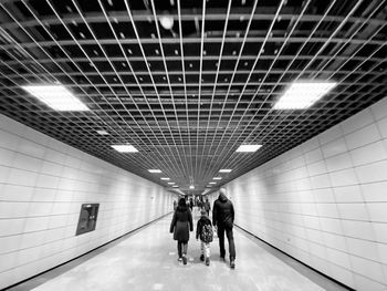 Rear view of people walking in underground walkway