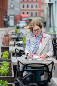 Woman sitting on table in city