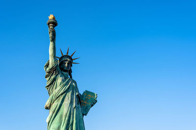 Low angle view of statue against blue sky