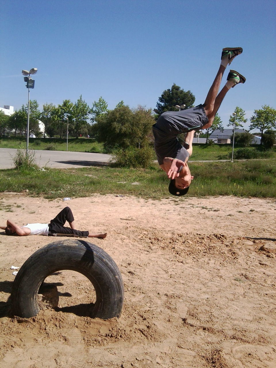 full length, lifestyles, jumping, leisure activity, casual clothing, mid-air, young adult, person, clear sky, tree, fun, young men, day, sunlight, enjoyment, outdoors, childhood, side view