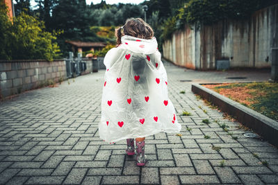 Rear view of girl standing on footpath