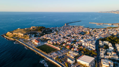 High angle view of buildings by sea against sky