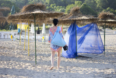 Rear view of people standing on beach