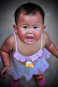 High angle portrait of cute baby girl crying while standing on road