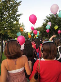 Rear view of people with balloons
