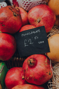 Fresh ripe pomegranates on sale at a marker, with a price tag.