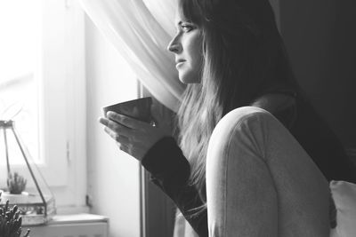 Side view of young woman at home