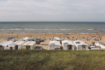 High angle view of huts at beach seen from grassy cliff