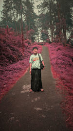 Full length portrait of young man standing on road