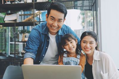 Portrait of smiling family sitting at home