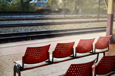 Empty chairs at railroad station platform