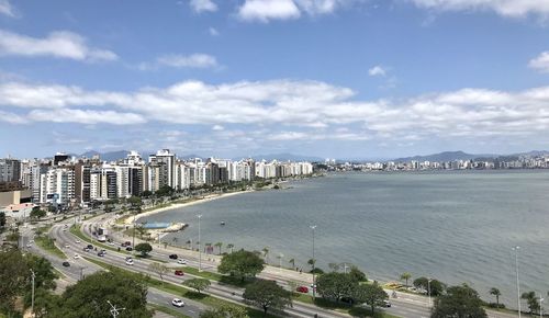 High angle view of city by sea against sky