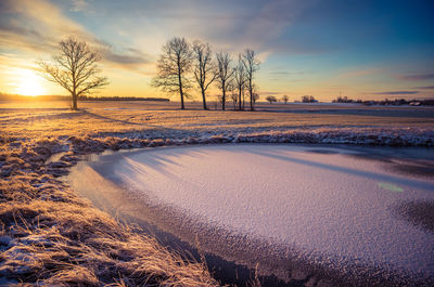 A beautiful frozen pond in the rural scene during the morning golden hour. 