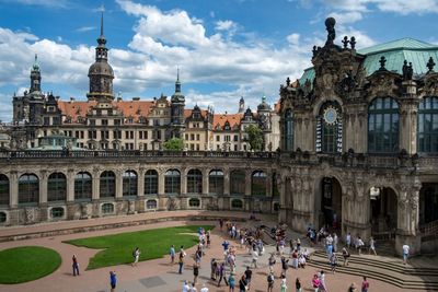 People at town square against cloudy sky