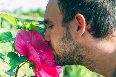 Close-up portrait of man with pink flower