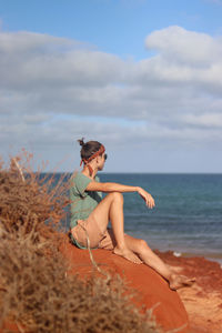 Profile portrait of young man on red sand beach