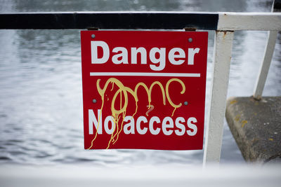 Close-up of warning sign on lake