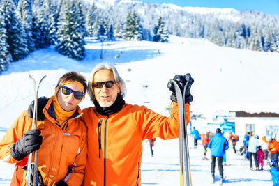 Portrait of friends standing on snow covered landscape