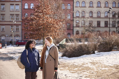 Female friends talking together outdoors in city surroundings