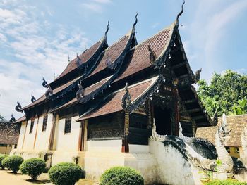 Low angle view of temple by building against sky