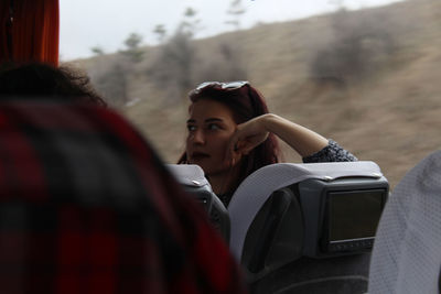 Woman looking away while sitting in bus