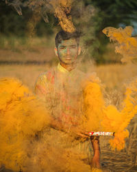 Photoshoot in man holding smoke bomb and celebrating festival