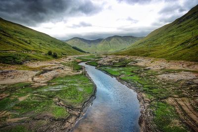 Scenic view of river amidst mountains against sky