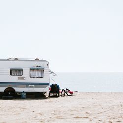 Caravan on beach against clear sky