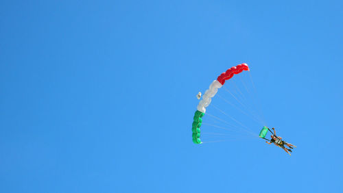 Low angle view of kite flying against clear blue sky