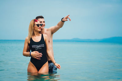 Young couple spending leisure time at beach against sky