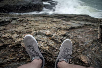 Low section of person relaxing on rock