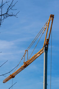 Low angle view of crane against sky